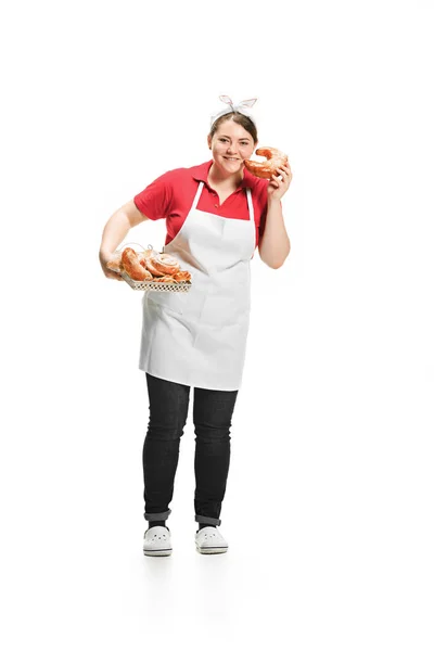 Portrait de mignonne femme souriante avec des pâtisseries dans ses mains en studio, isolée sur fond blanc — Photo