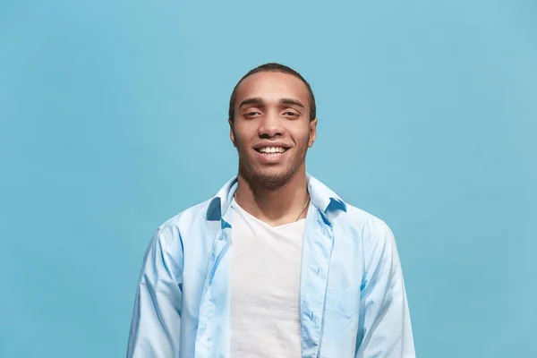 O homem de negócios feliz de pé e sorrindo contra o fundo azul . — Fotografia de Stock