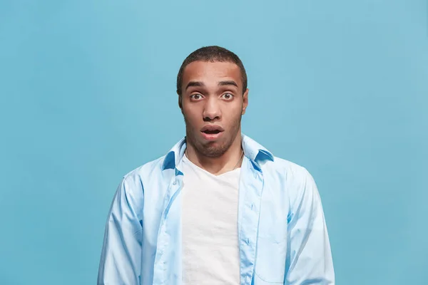 The young attractive man looking suprised isolated on blue — Stock Photo, Image