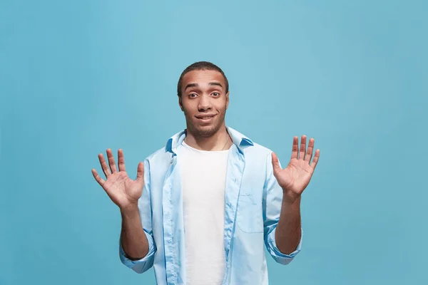 Der junge attraktive Mann schaut überrascht isoliert auf blau — Stockfoto