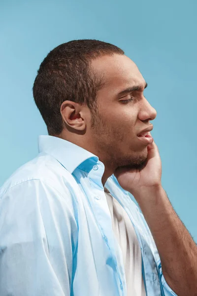 Сумний афроамериканський чоловік має зубний біль. на синьому фоні — стокове фото