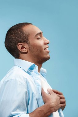 Ayakta ve mavi arka planı gülümseyen mutlu işadamı.