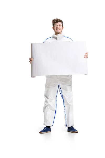 Young male decorator painting with a poster climbed a ladder isolated on white background. — Stock Photo, Image