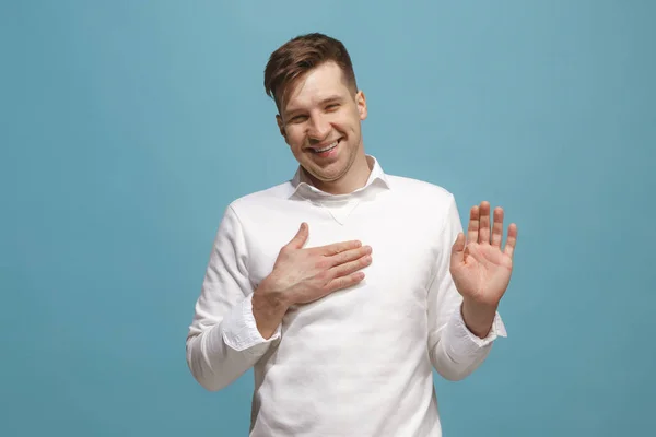 El hombre de negocios feliz de pie y sonriendo contra el fondo azul . — Foto de Stock