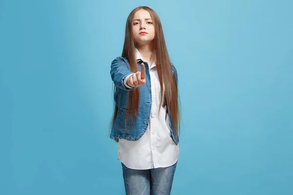 Щаслива дівчина-підліток вказує вам, портрет на половину довжини крупним планом на синьому фоні . — стокове фото
