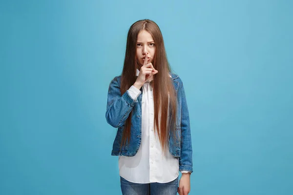 A fiatal tini lány suttogott a titok mögött a kezét, mint kék háttér — Stock Fotó