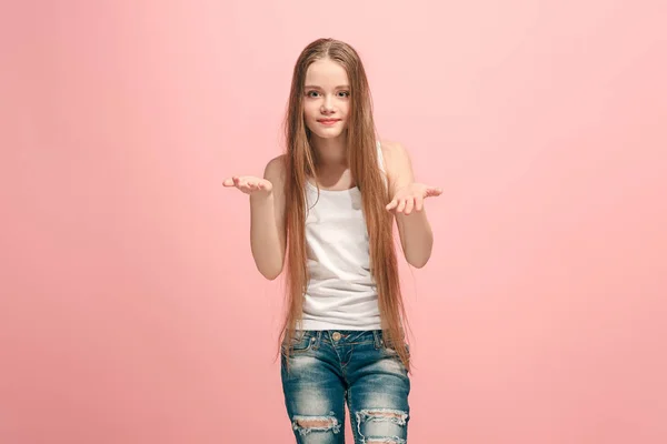 Das fröhliche Teenie-Mädchen bietet etwas vor rosa Hintergrund. — Stockfoto