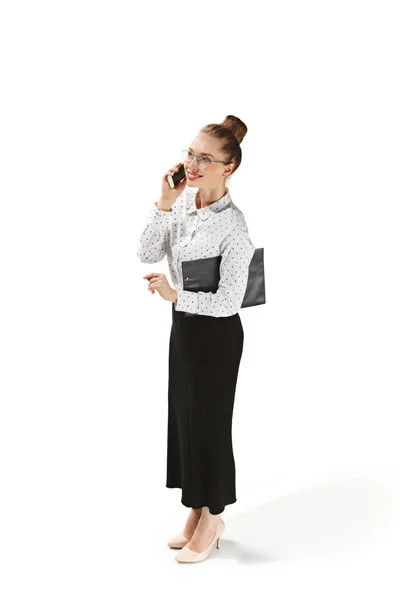 Full length portrait of a smiling female teacher holding a folder isolated against white background — Stock Photo, Image