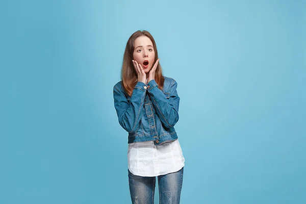 Hermosa chica adolescente mirando sorprendido aislado en azul —  Fotos de Stock