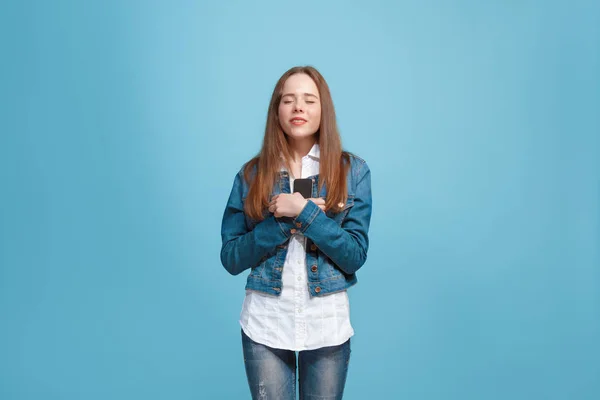 Hermosa chica adolescente mirando sorprendido aislado en azul — Foto de Stock