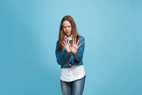Dudosa chica adolescente pensativa rechazando algo contra el fondo azul — Foto de Stock