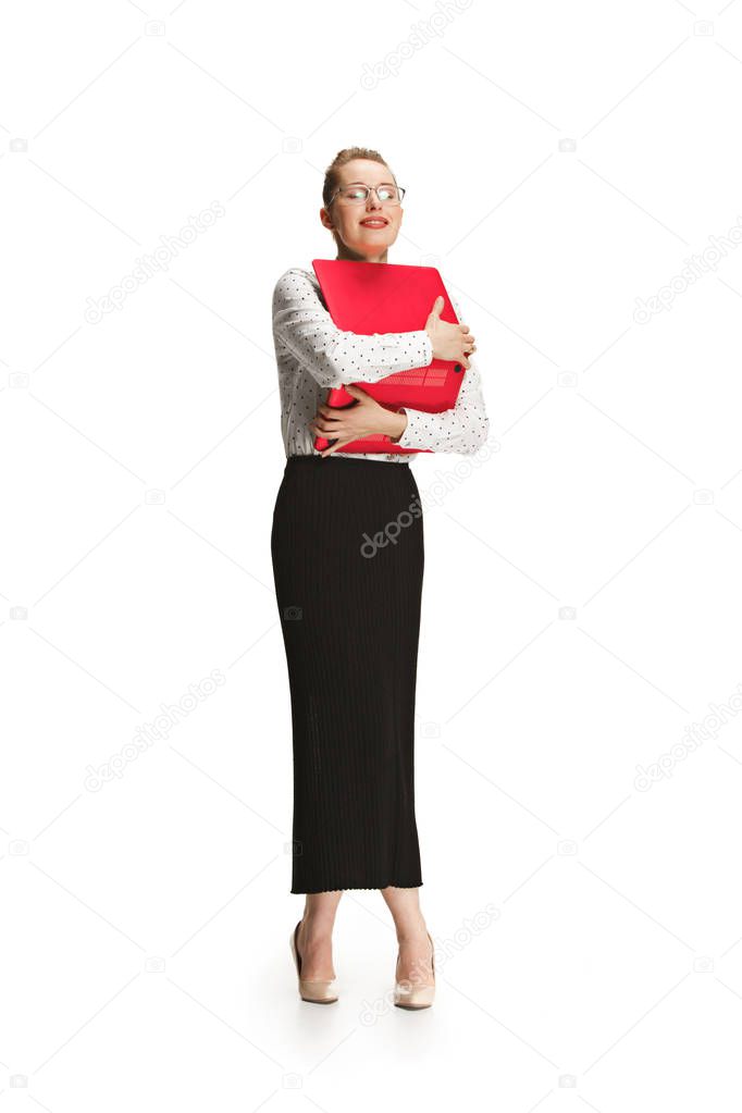 Full length portrait of a smiling female teacher holding a laptop isolated against white background