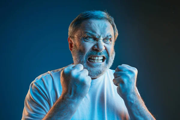 The senior emotional angry man screaming on blue studio background — Stock Photo, Image