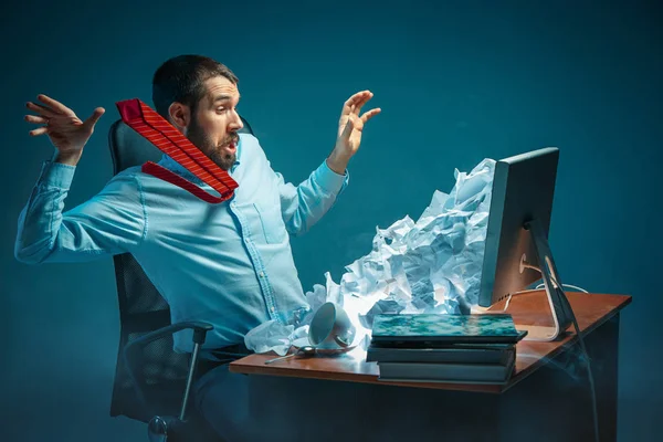 Junger gestresster gutaussehender Geschäftsmann, der am Schreibtisch im modernen Büro arbeitet, am Laptop-Bildschirm schreit und wütend über Spam ist — Stockfoto