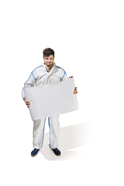 Young male decorator painting with a poster climbed a ladder isolated on white background. — Stock Photo, Image