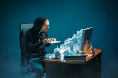 Genç yakışıklı işadamı dizüstü bilgisayar ekranında bağırmak ve spam hakkında kızgın modern ofis masasında çalışan vurguladı
