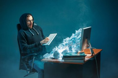 Genç yakışıklı işadamı dizüstü bilgisayar ekranında bağırmak ve spam hakkında kızgın modern ofis masasında çalışan vurguladı