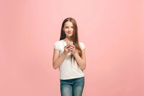 Das fröhliche Teenager-Mädchen, das vor rosa Hintergrund steht und lächelt. — Stockfoto