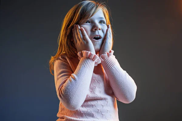 La jeune adolescente attrayante regardant surprise isolée sur bleu foncé — Photo