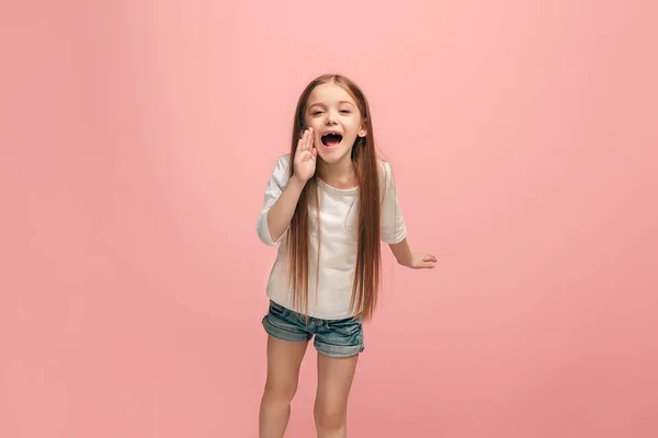 Ізольовані на рожевий молодий випадковий підліток дівчина кричить в студії — стокове фото