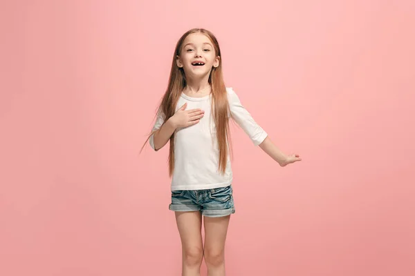 Das fröhliche Teenager-Mädchen, das vor rosa Hintergrund steht und lächelt. — Stockfoto