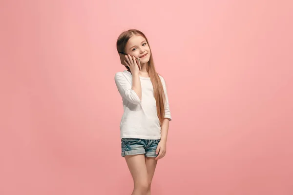 Счастливая девушка-подросток стоит и улыбается на розовом фоне . — стоковое фото
