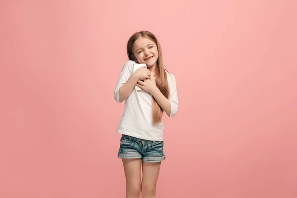 Ευτυχής έφηβος κορίτσι στέκεται και χαμογελαστός σε ροζ φόντο. — Φωτογραφία Αρχείου