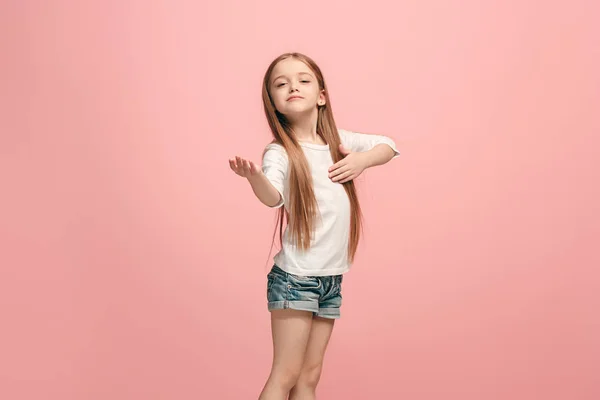 Das fröhliche Teenager-Mädchen, das vor rosa Hintergrund steht und lächelt. — Stockfoto