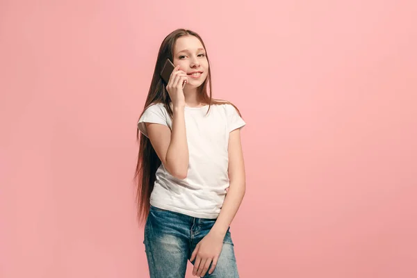 Mutlu genç kız ayakta ve pembe arka plan üzerinde gülümseyen. — Stok fotoğraf