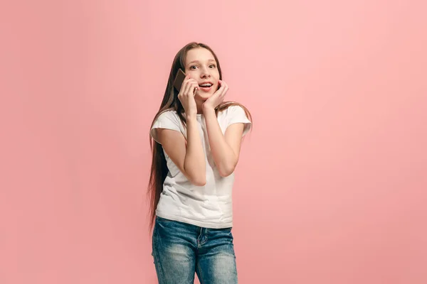 Das fröhliche Teenager-Mädchen, das vor rosa Hintergrund steht und lächelt. — Stockfoto