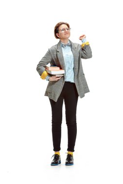 Beyaz arka plan üzerinde izole kitap tutan mutlu gülümseyen kız öğrencinin tam uzunlukta portresi