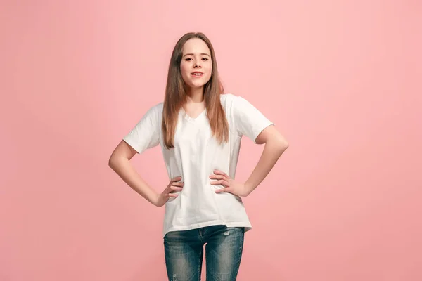 Das fröhliche Teenager-Mädchen, das vor rosa Hintergrund steht und lächelt. — Stockfoto