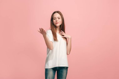 Mutlu genç kız ayakta ve pembe arka plan üzerinde gülümseyen.