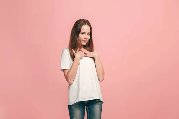 Das fröhliche Teenager-Mädchen, das vor rosa Hintergrund steht und lächelt. — Stockfoto