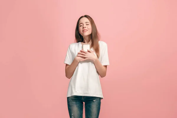 A menina adolescente feliz de pé e sorrindo contra o fundo rosa . — Fotografia de Stock