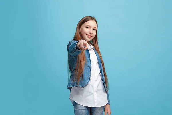 Счастливая девочка-подросток, указывающая на тебя, портрет крупным планом на голубом фоне . — стоковое фото