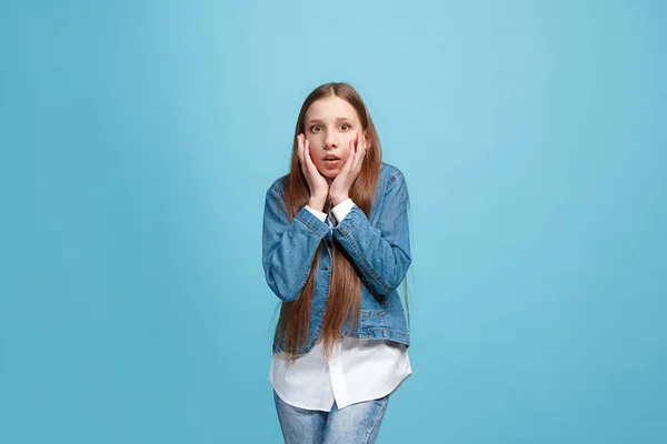 Hermosa chica adolescente mirando sorprendido aislado en azul — Foto de Stock