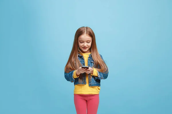 La chica adolescente feliz de pie y sonriendo contra el fondo azul . —  Fotos de Stock