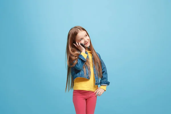 La chica adolescente feliz de pie y sonriendo contra el fondo azul . —  Fotos de Stock