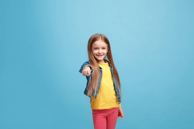 Sen, yarı uzunluk portre portre mavi zemin üzerine işaret mutlu genç kız.