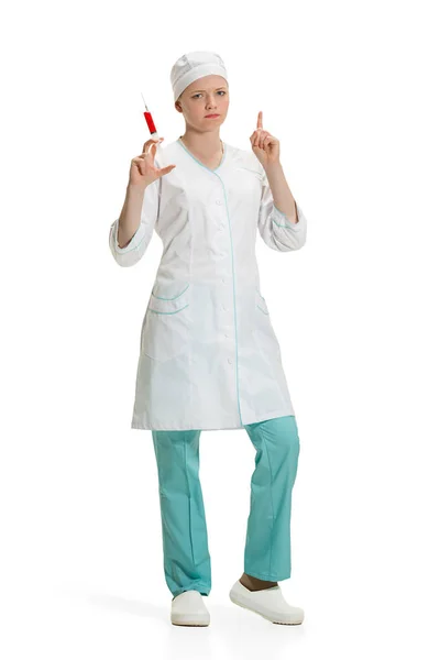 Bela jovem médico em roupão médico segurando seringa na mão . — Fotografia de Stock