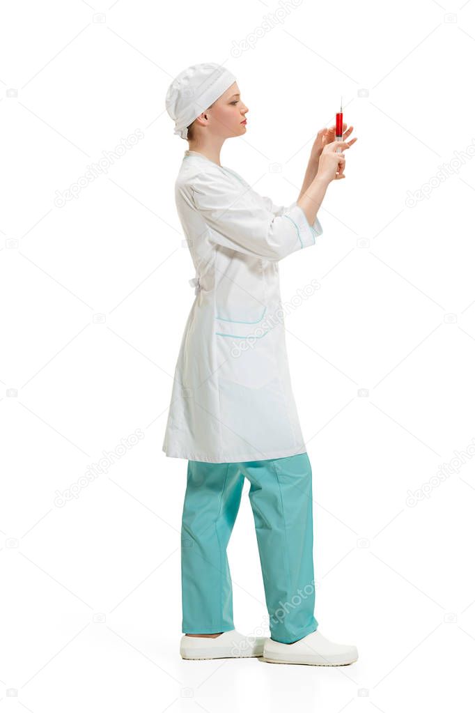 beautiful young woman doctor in medical robe holding syringe in hand.