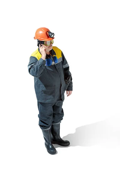 The studio shot of senior bearded male miner standing at the camera on a white background. — Stock Photo, Image