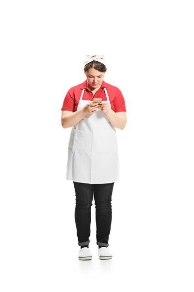 Portret van leuke vrouw met mobiele telefoon in haar handen in de studio, geïsoleerd op witte achtergrond — Stockfoto