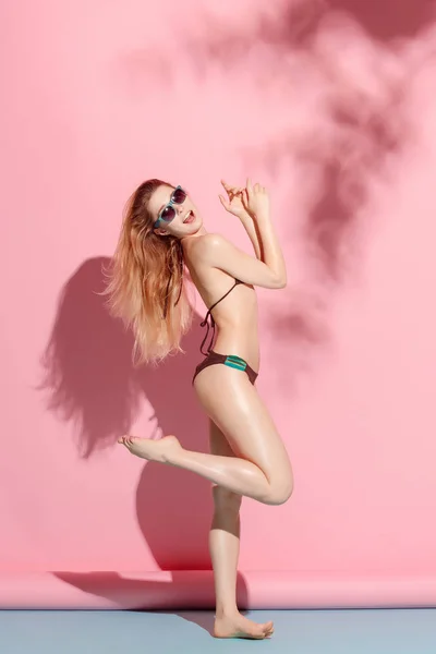분홍색 배경에 포즈입니다 수영복에 스튜디오에서 선글라스 비키니 피부와 — 스톡 사진