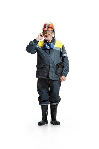 The studio shot of happy senior bearded male miner standing at the camera with smartphone on a white background. — Stock Photo, Image