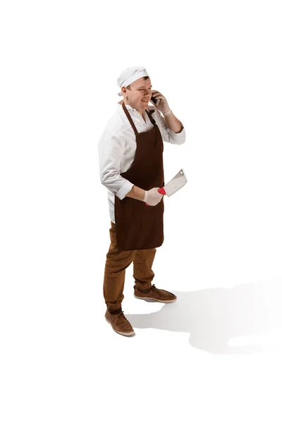 Carnicero sonriente posando con una cuchilla aislada sobre fondo blanco — Foto de Stock