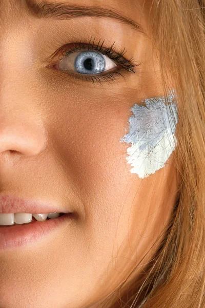 Retrato de una mujer con la bandera de la Argentina pintada en su rostro . — Foto de Stock