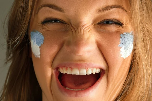 Porträt einer Frau mit der Flagge Argentiniens im Gesicht. — Stockfoto