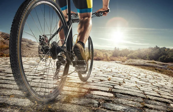 Yksityiskohta pyöräilijä mies jalat ratsastus maastopyörä ulkona polkua maan tiellä — kuvapankkivalokuva